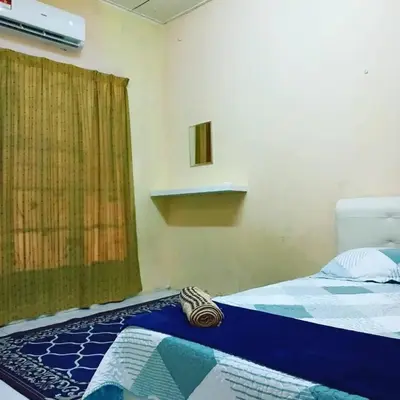a bedroom with a bed and a window with a curtain at Homestay Musafir 3.0 in Seri Iskandar
