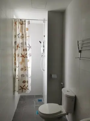 a bathroom with a toilet and a shower curtain at Taiping Comfort Condo Homestay in Taiping