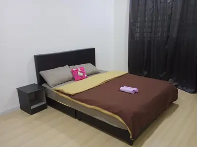 a bed with two pink pillows on top of it at Taiping Comfort Condo Homestay in Taiping