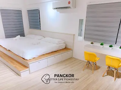 a bedroom with a bed and a desk and two chairs at Pangkor Better Life Cozy Studio-walking 2min to beach,1-4pax in Pangkor