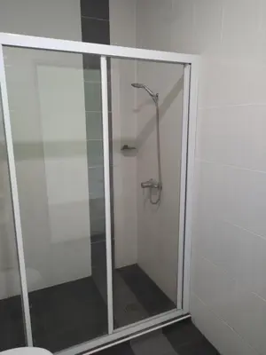a shower with a glass door in a bathroom at Marina Couple Home Stay, No Counter reception, please look details in Lumut