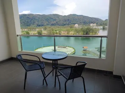 a balcony with a table and chairs and a large window at Marina Couple Home Stay, No Counter reception, please look details in Lumut