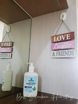 a bathroom with a bottle of soap and a sign at Best Sekinchan homestay in Sekincan