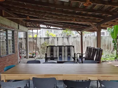 a large wooden table and chairs in a patio at Sayang Di Kaki Bukit Homestay Near Icon City Bukit Mertajam in Bukit Mertajam