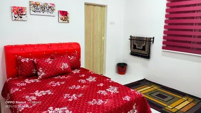 a bedroom with a red bed with a red comforter at Rania Homestay With Private Pool Seri Iskandar Perak Near UTP UITM in Kampong Bota Road
