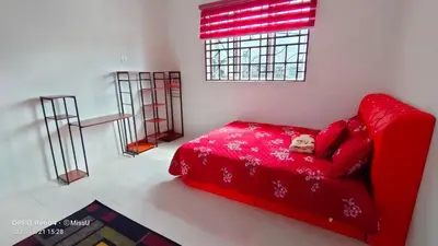 a red couch with a dog laying on it in a room at Rania Homestay With Private Pool Seri Iskandar Perak Near UTP UITM in Kampong Bota Road