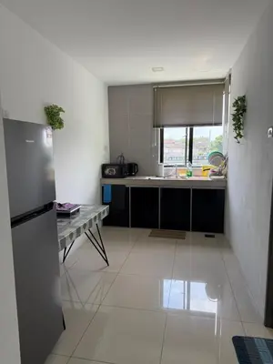 a kitchen with a refrigerator and a table in it at KH Water Park Manhattan Condo Ipoh Homestay in Kampong Pinji