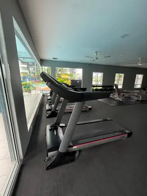 a row of treadmills in a gym with a large window at KH Water Park Manhattan Condo Ipoh Homestay in Kampong Pinji