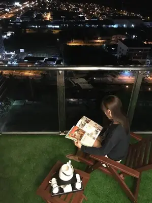 a woman sitting on a bench reading a magazine at Pearl Rice Garden \uff08cottage style\uff09\u7c73\u6a02\u574a\u9802\u5c64\u7530\u56ed\u5f0f\u9ad8\u7ea7\u516c\u5bd3 in Sekincan