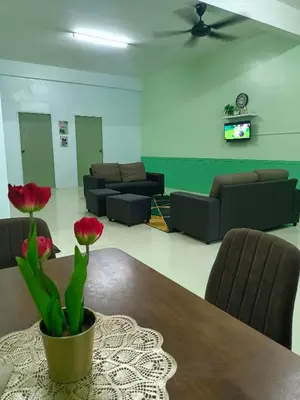 a living room with a table and chairs and a couch at Homestay Muslim in Kuala Ketil