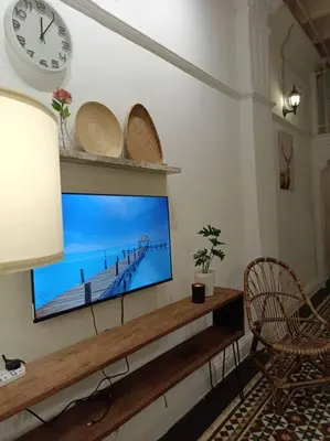 a living room with a flat screen tv on a wall at UNESCO Bohemian Style Heritage House at Georgetown 5BR 14 pax in George Town