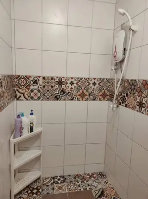 a bathroom with a shower and a tiled floor at UNESCO Bohemian Style Heritage House at Georgetown 5BR 14 pax in George Town