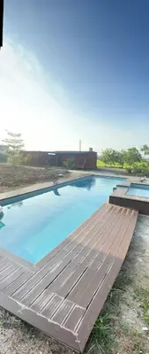 a large swimming pool with a wooden deck at HOMESTAY Kampong KOTA AUR Resort with swimming pool, Kepala Batas, SEBERANG PERAI, PENANG -MOTAC registered Awarded ASEAN homestay standard Malaysia AWARD 2023-2028 Only 3 minutes from viral KG AGONG in Kepala Batas