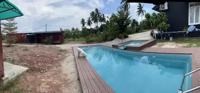 a large blue swimming pool in a yard at HOMESTAY Kampong KOTA AUR Resort with swimming pool, Kepala Batas, SEBERANG PERAI, PENANG -MOTAC registered Awarded ASEAN homestay standard Malaysia AWARD 2023-2028 Only 3 minutes from viral KG AGONG in Kepala Batas