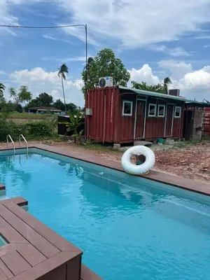 a swimming pool with a house and a life preserver at HOMESTAY Kampong KOTA AUR Resort with swimming pool, Kepala Batas, SEBERANG PERAI, PENANG -MOTAC registered Awarded ASEAN homestay standard Malaysia AWARD 2023-2028 Only 3 minutes from viral KG AGONG in Kepala Batas