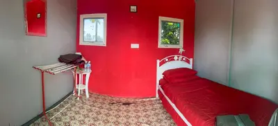 a red room with a bed and a red wall at HOMESTAY Kampong KOTA AUR Resort with swimming pool, Kepala Batas, SEBERANG PERAI, PENANG -MOTAC registered Awarded ASEAN homestay standard Malaysia AWARD 2023-2028 Only 3 minutes from viral KG AGONG in Kepala Batas