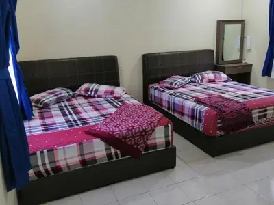two beds sitting next to each other in a bedroom at Kamar Musafir MMS in Ipoh