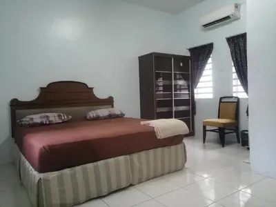 a bedroom with a bed and a chair at Kamar Musafir MMS in Ipoh