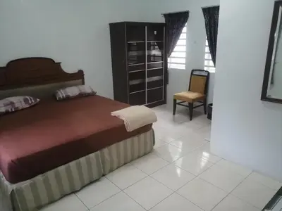 a bedroom with a bed and a chair at Kamar Musafir MMS in Ipoh