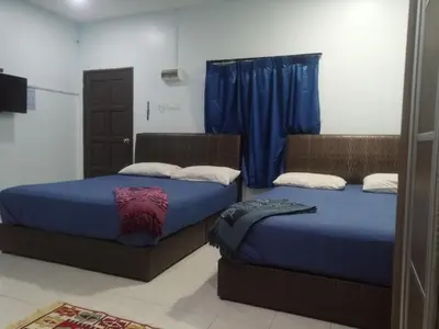 two beds sitting next to each other in a room at Kamar Musafir MMS in Ipoh