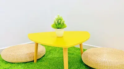 a yellow table with a plant on top of grass at Pangkor Better Life Minimalist Beach Villa-13 to15pax Free WiFi in Pangkor