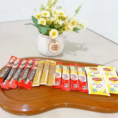 a table with packets of toothpaste and a vase with flowers at Pangkor Better Life Minimalist Beach Villa-13 to15pax Free WiFi in Pangkor