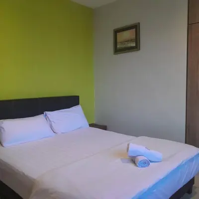 a bed with two towels sitting on top of it at Reintree Lodge Hotel in Ipoh