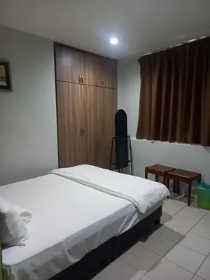 a bedroom with a bed and a wooden cabinet at Reintree Lodge Hotel in Ipoh