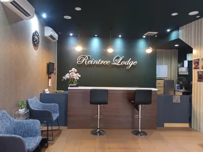 a waiting room with a counter with chairs and aurance lobby at Reintree Lodge Hotel in Ipoh