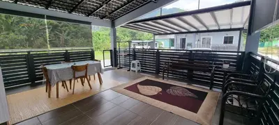 a dining room with a table and chairs on a balcony at Tambun Hillview Cottage 1 in Tambun