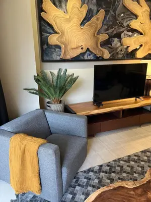 a living room with a couch and a flat screen tv at By The Sea Beachfront Designer Suites Penang - Managed by Art of Tree in Batu Ferringhi