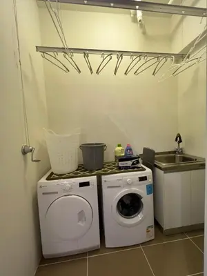 a laundry room with a washing machine and a sink at By The Sea Beachfront Designer Suites Penang - Managed by Art of Tree in Batu Ferringhi