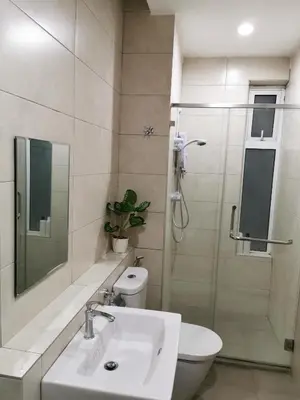 a bathroom with a toilet and a sink and a shower at Octagon Ipoh Family Suites in Ipoh