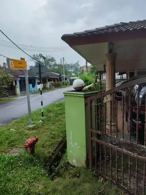 a red fire hydrant sitting next to a house at Mai KKB Homestay in Kuala Kubu Bharu Taman Juta in Kuala Kubu Baharu