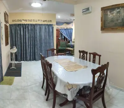 a dining room with a white table and chairs at Mai KKB Homestay in Kuala Kubu Bharu Taman Juta in Kuala Kubu Baharu
