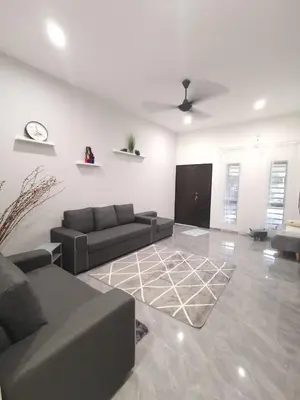 a living room with two couches and a clock on the wall at Wellson Home Ipoh 58 10px \u5168\u65b0\u94fe\u63a5\u5f0f\u6c11\u5bbf\u6709\u4e24\u95f4 in Ipoh