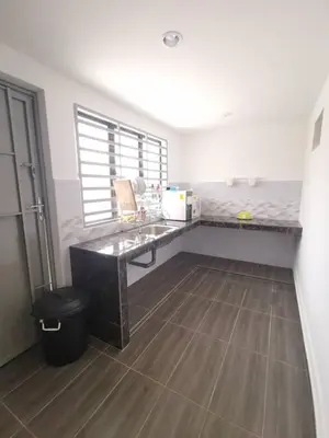 a kitchen with a counter and a table in a room at Wellson Home Ipoh 58 10px \u5168\u65b0\u94fe\u63a5\u5f0f\u6c11\u5bbf\u6709\u4e24\u95f4 in Ipoh