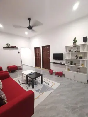 a living room with a red couch and a table at Wellson Home Ipoh 56 10px \u5168\u65b0\u94fe\u63a5\u5f0f\u6c11\u5bbf\u6709\u4e24\u95f4 in Ipoh