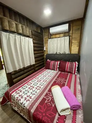 a bedroom with a bed with a blanket on it at HOMESTAY DUSUN ANA BALUN in Slim River