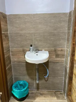 a bathroom with a sink and a blue bag at HOMESTAY DUSUN ANA BALUN in Slim River