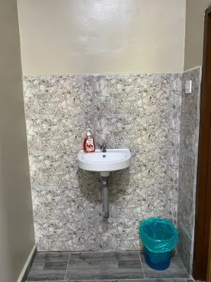 a bathroom with a sink in a stone wall at HOMESTAY DUSUN ANA BALUN in Slim River