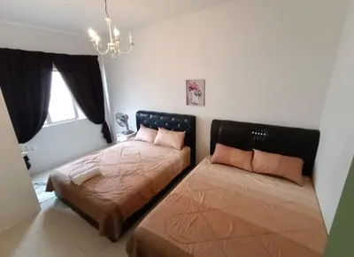 a bedroom with two beds and a chandelier at Muslim Boutique Apartment with Balcony in Tanah Rata