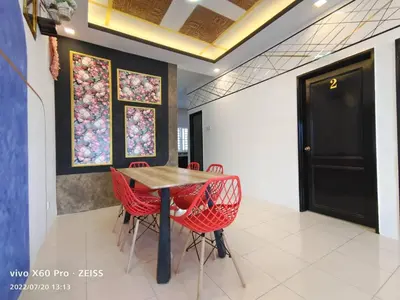 a dining room with a wooden table and red chairs at ifloral CH1 in Tanah Rata
