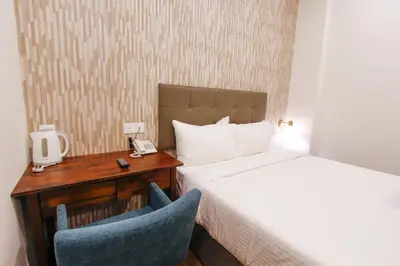 a hotel room with a bed and a desk and a chair at CitiVilla Hotel Penang in George Town