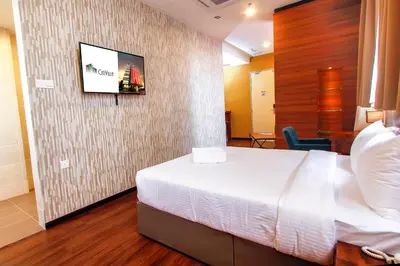 a hotel room with a bed and a tv on a wall at CitiVilla Hotel Penang in George Town
