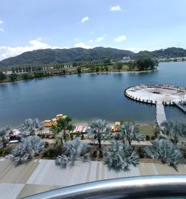 a view of a lake with palm trees and a beach at Glossy Marina Homestays in Lumut