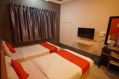 a hotel room with two beds and a television at V HOTEL in Teluk Intan