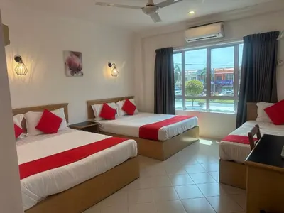 a hotel room with two beds and a window at V HOTEL in Teluk Intan