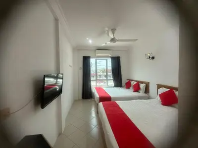 a hotel room with two beds and a window at V HOTEL in Teluk Intan
