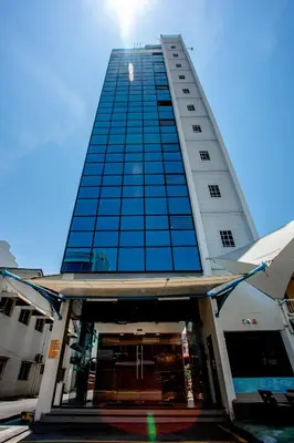 a tall building with blue glass windows on it at PP Hotel Penang in George Town